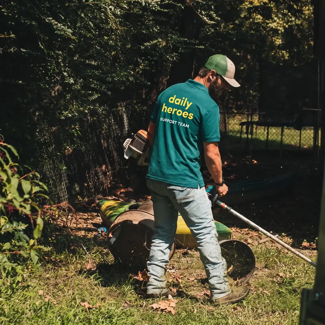 A Daily Heroes support team member trimming an overgrown garden