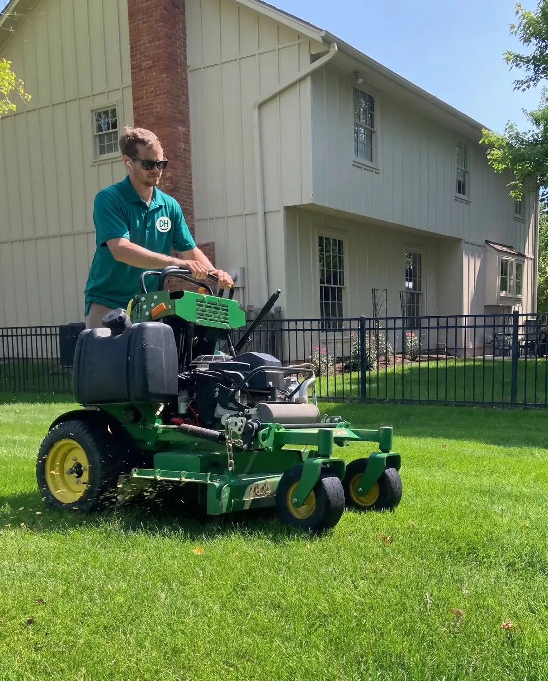 A Daily Heroes worker mowing a lawn